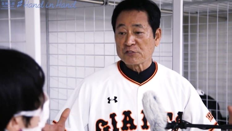 ブルペンで巨人のユニフォームを着た中畑清さんがインタビューに答えている様子