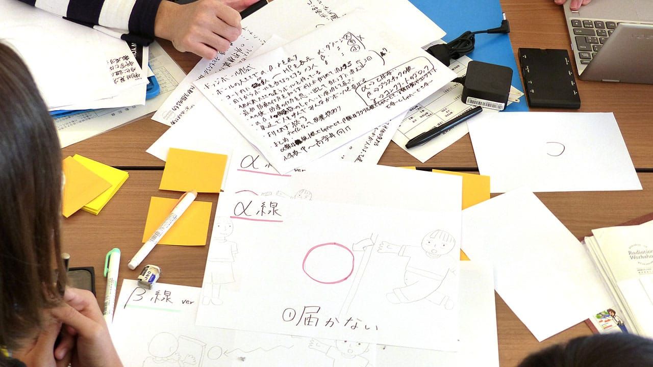 放射線についての内容が書き込まれている多数のメモ用紙や筆記用具の写真