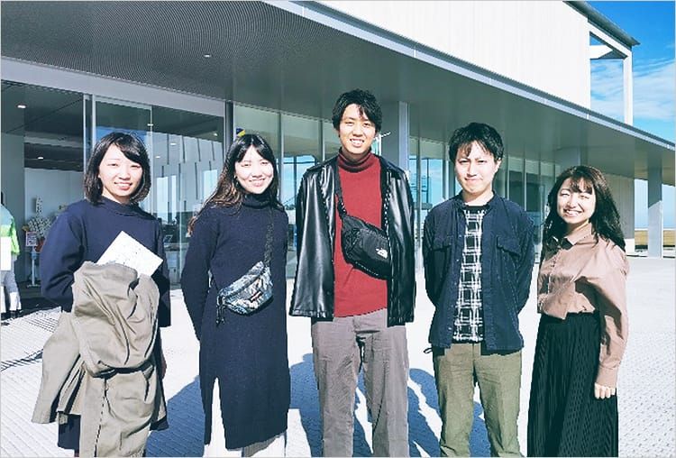 伝承館に来館した男女5名が入り口の前で並んでいる集合写真