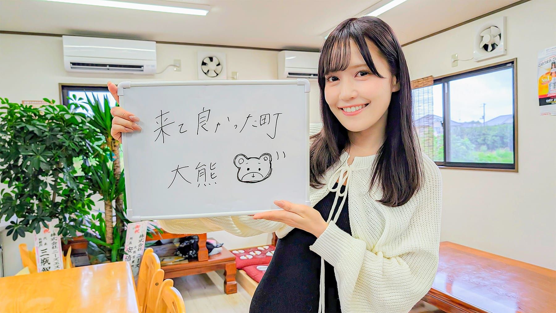 「来て良かった町大熊」と書かれたホワイトボードを掲げる女性アイドルグループ「＝LOVE」のメンバー諸橋沙夏さんの写真