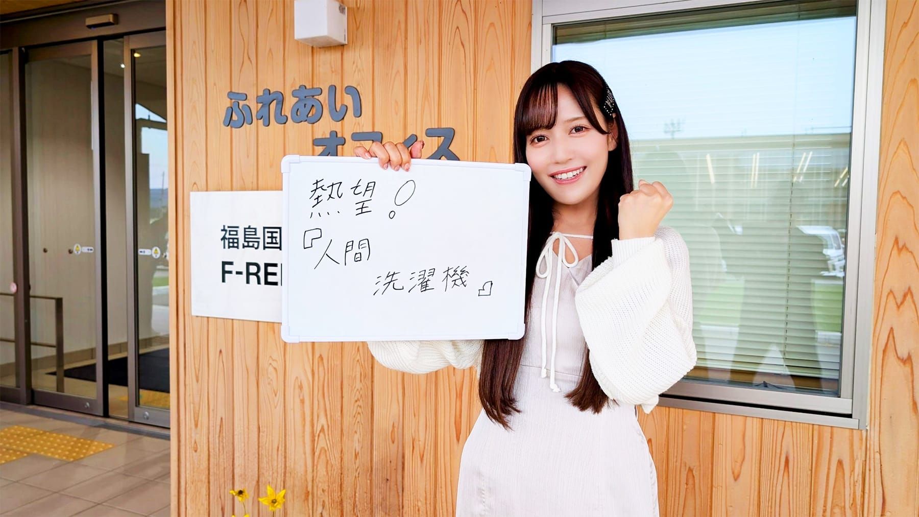 「熱望！人間洗濯機」と書かれたホワイトボードを掲げる女性アイドルグループ「＝LOVE」のメンバー諸橋沙夏さんの写真