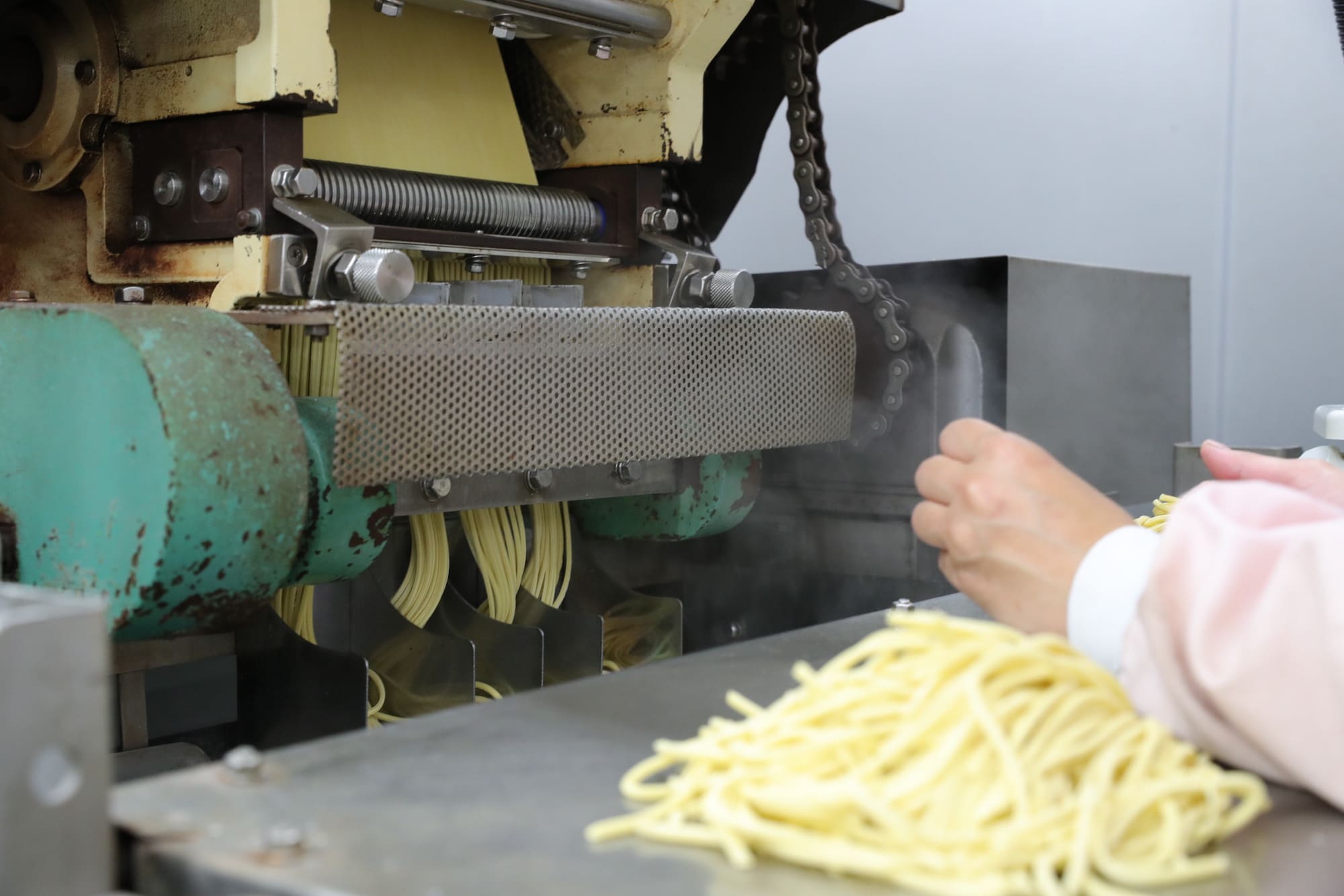 薄くした麺の塊を機械で切り出す